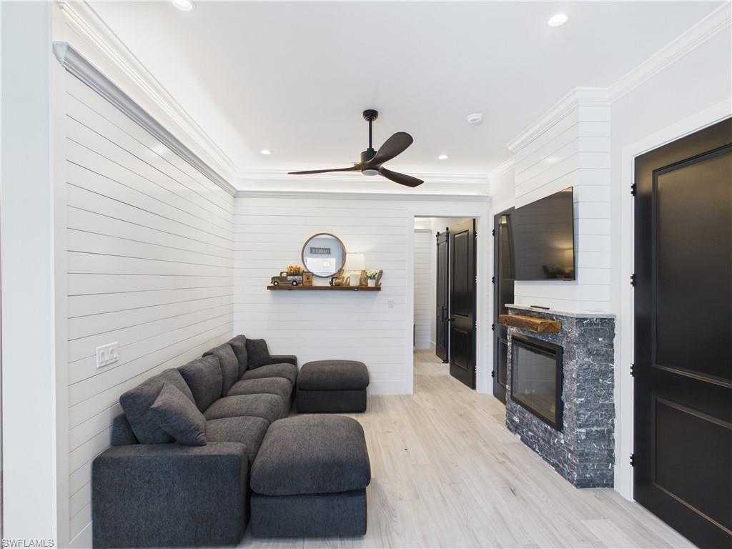 3650 Sunset Boulevard Naples, FL 34112 - Photo 4 of 26 Living area featuring white shiplap walls, light wood-finish flooring, and a contemporary ceiling fan