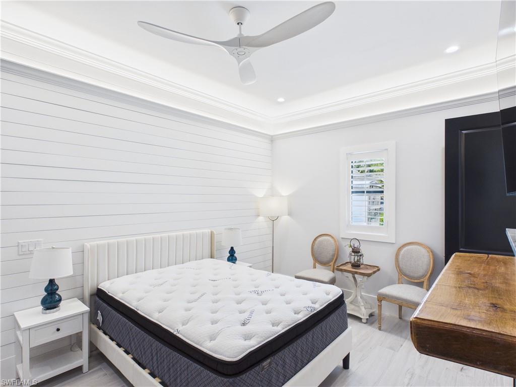 3650 Sunset Boulevard Naples, FL 34112 - Photo 9 of 26 Bedroom featuring shiplap accent wall, crown molding, tray ceiling with recessed lighting, and a ceiling fan
