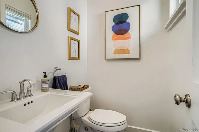 a bathroom with a toilet a sink and mirror