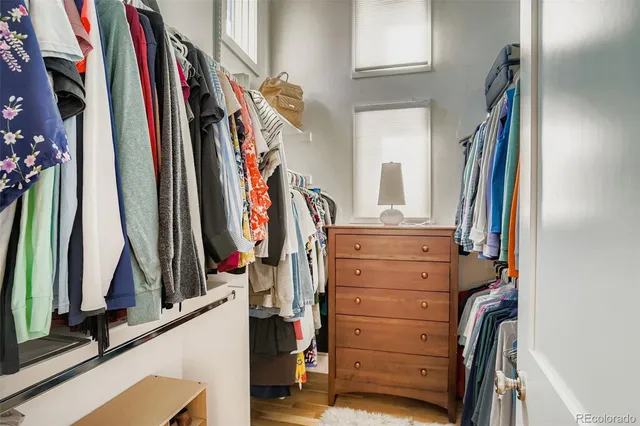 a view of walk in closet with clothes and shoes