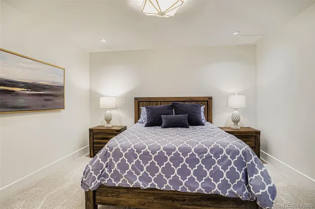 a bedroom with a bed and painting on the wall