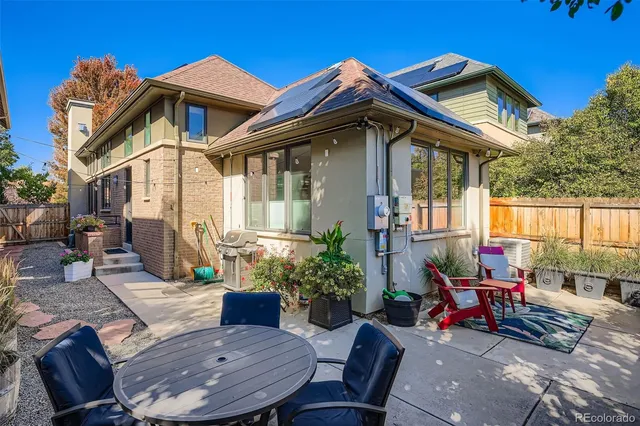 a view of a house with a wooden bench in a patio