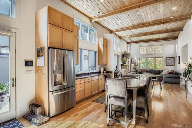 a kitchen with sink a refrigerator and chairs