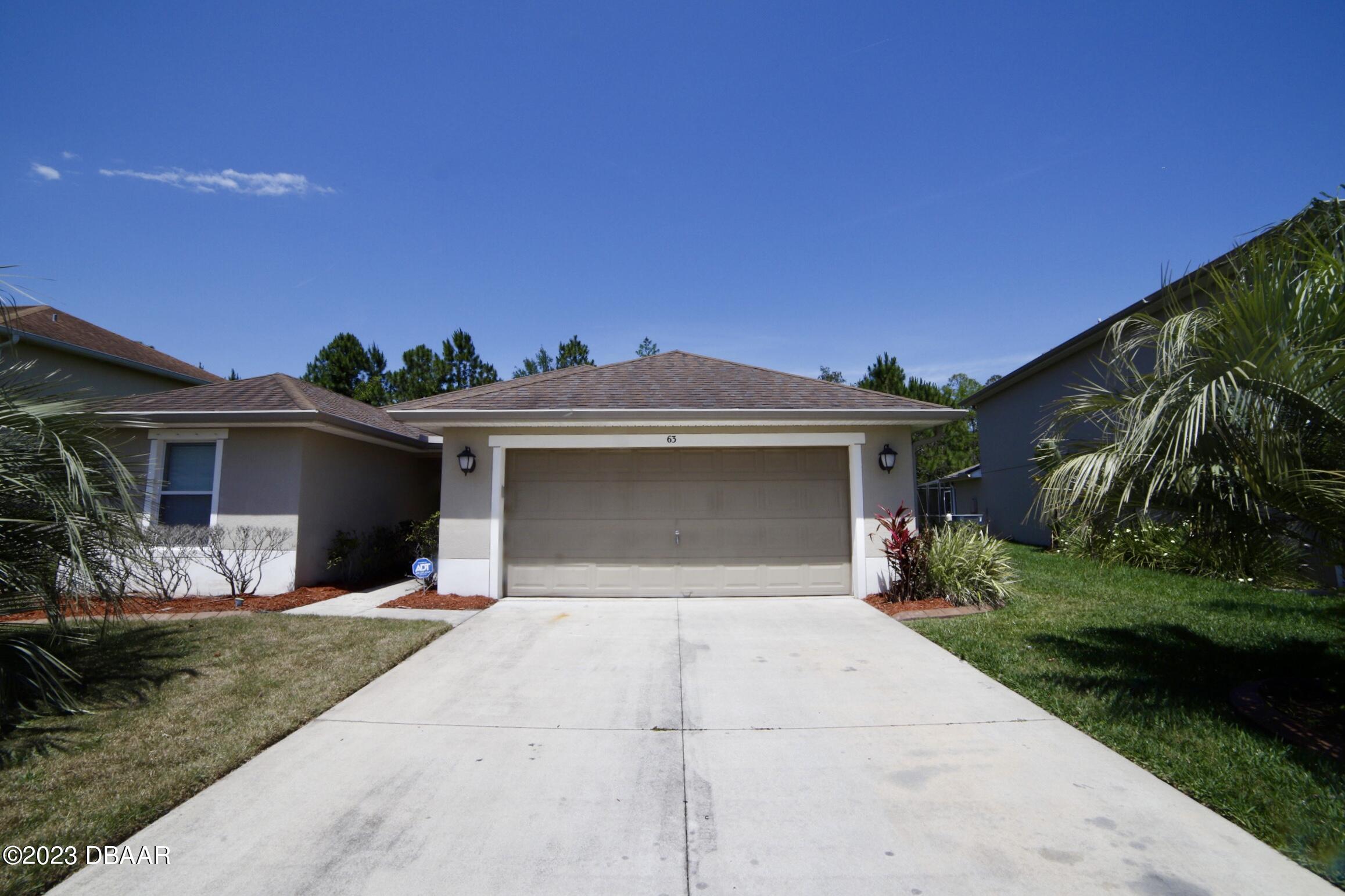 a front view of a house with yard and garage