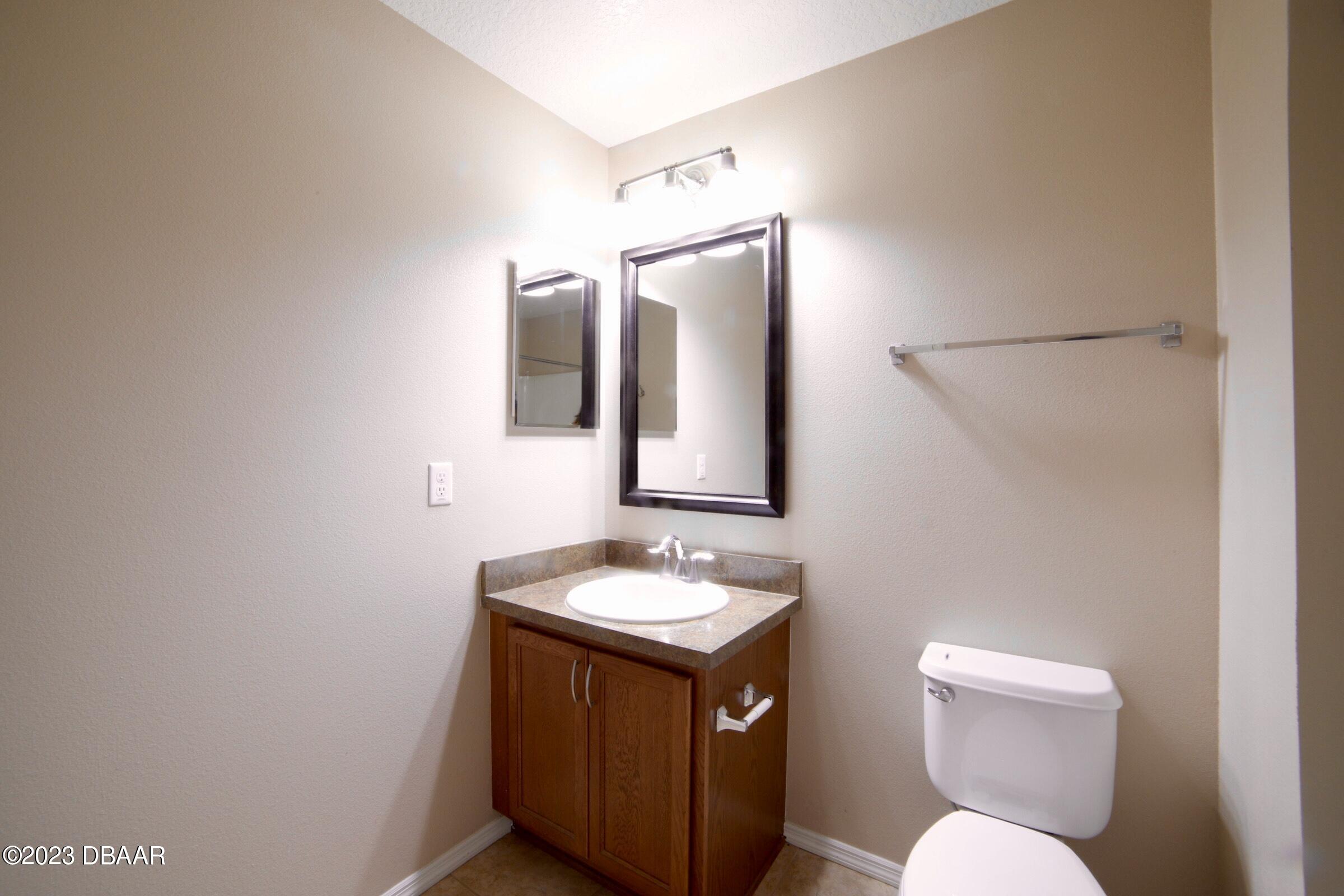 63 Levee Lane Ormond Beach, FL 32174 - Photo 13 of 41 a bathroom with a toilet sink and mirror