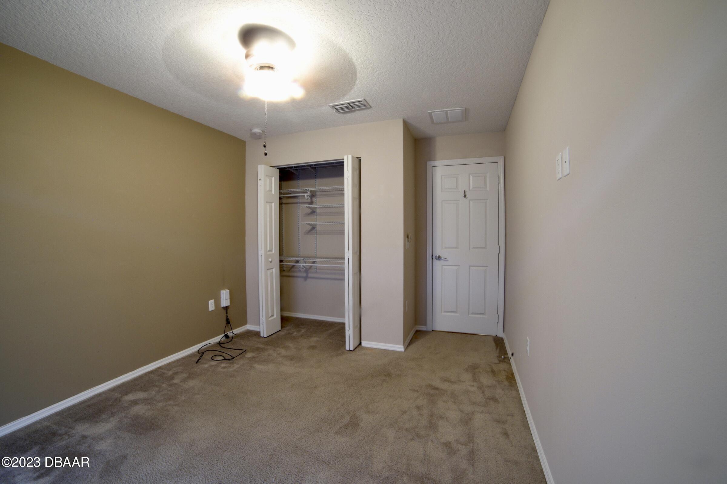 63 Levee Lane Ormond Beach, FL 32174 - Photo 17 of 41 an empty room with closet and windows
