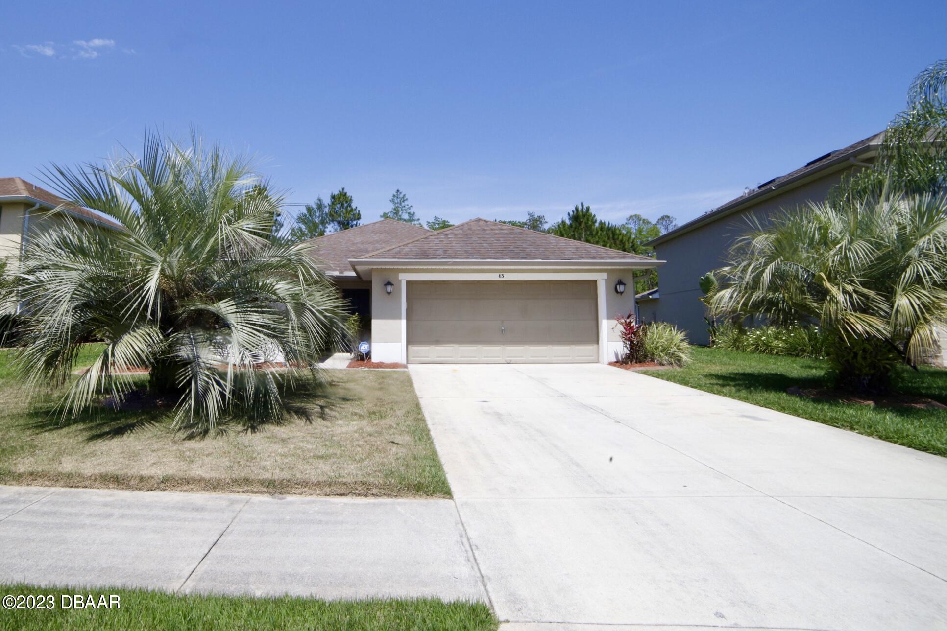 63 Levee Lane Ormond Beach, FL 32174 - Photo 2 of 41 a front view of a house with a yard and garage