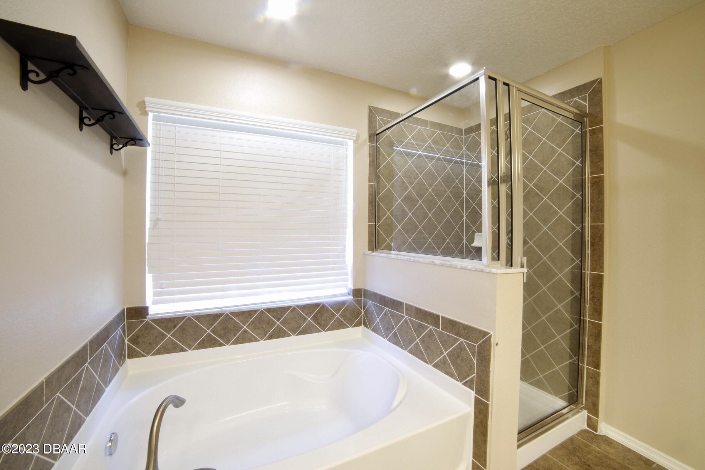 63 Levee Lane Ormond Beach, FL 32174 - Photo 25 of 41 a bathroom with a bathtub and a shower