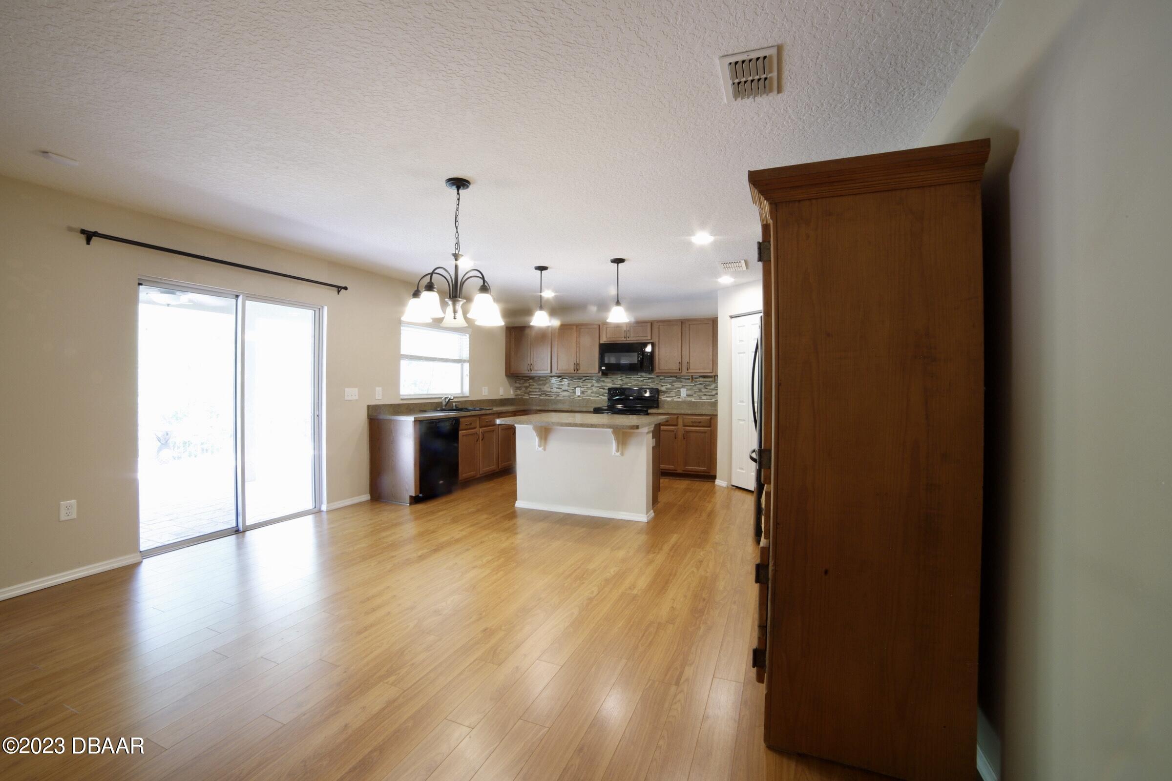 63 Levee Lane Ormond Beach, FL 32174 - Photo 32 of 41 a large kitchen with granite countertop a large counter top a sink stainless steel appliances and cabinets