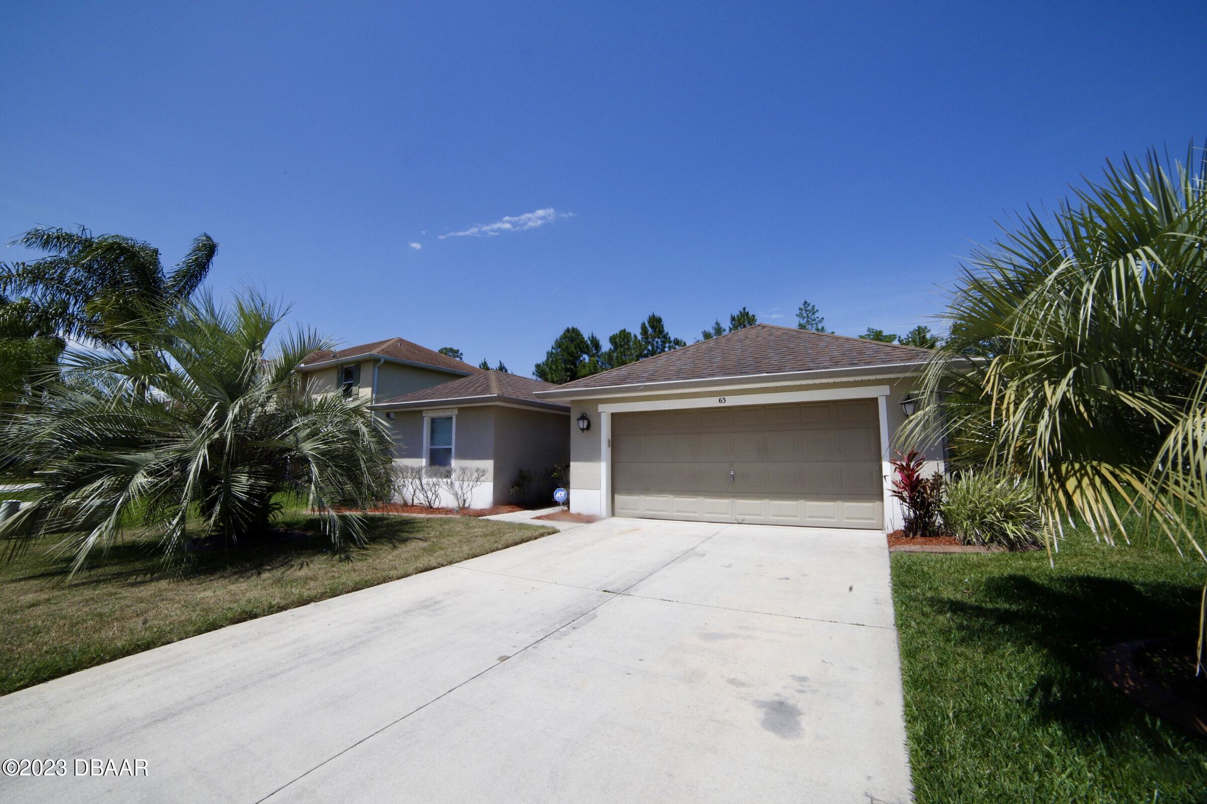 63 Levee Lane Ormond Beach, FL 32174 - Photo 4 of 41 a front view of a house with a yard and garage