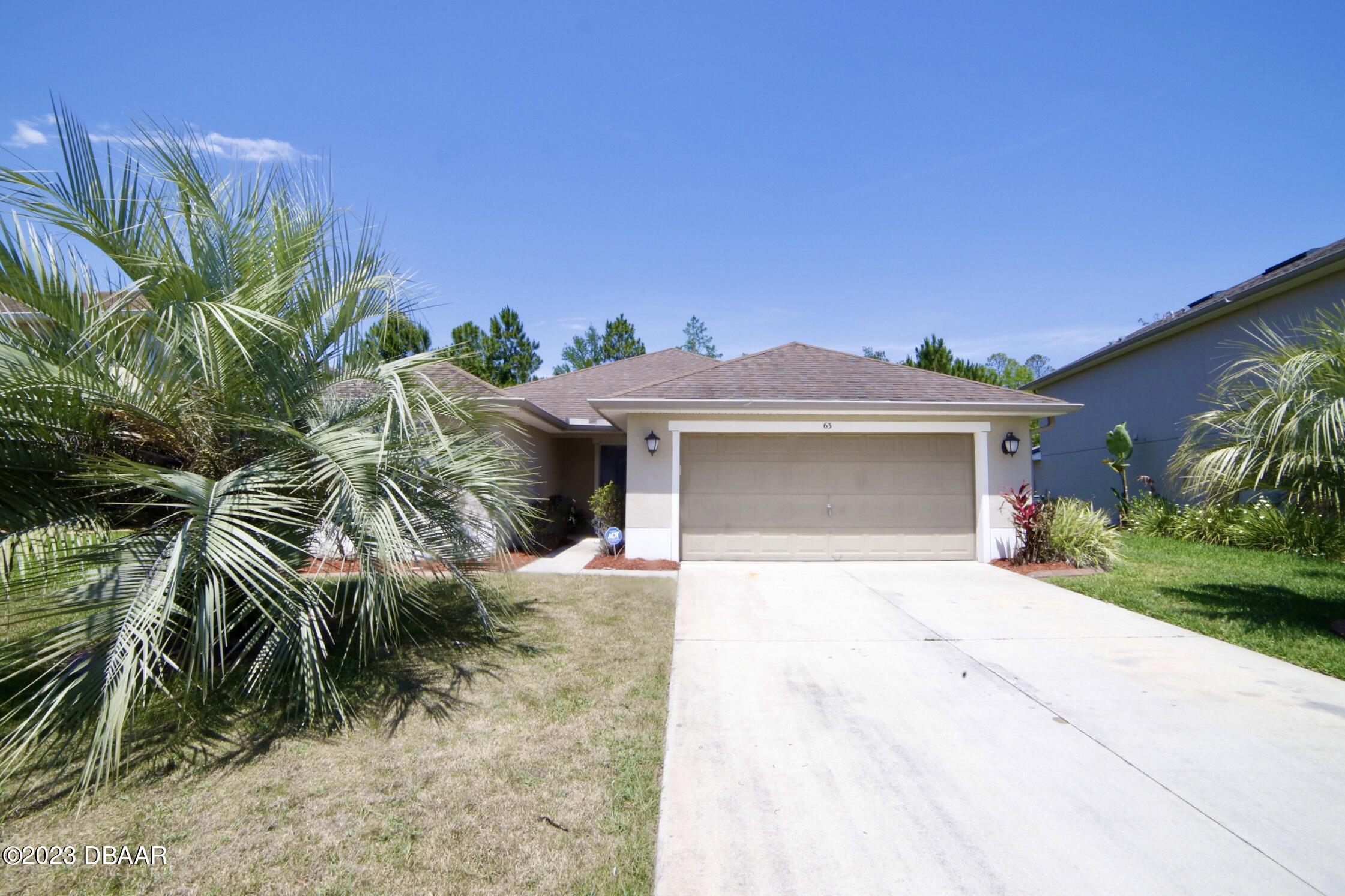 63 Levee Lane Ormond Beach, FL 32174 - Photo 7 of 41 a front view of a house with a yard and garage