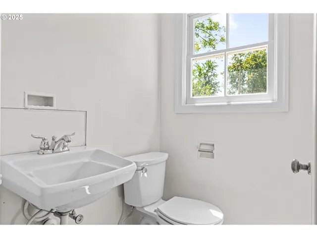 a bathroom with a sink a toilet and a window