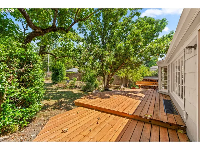 a view of backyard with wooden floor and fence