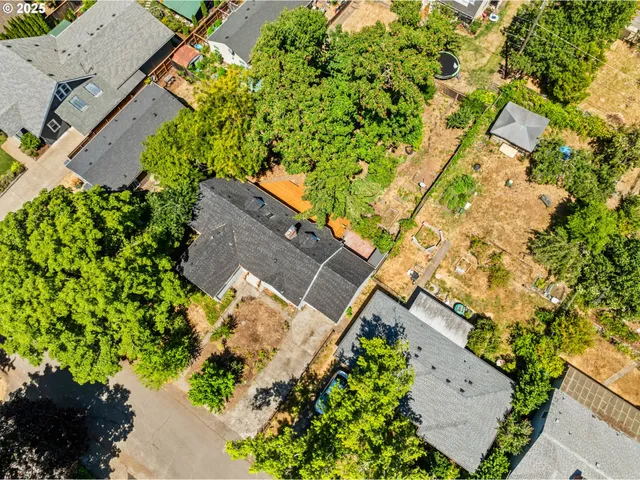 an aerial view of residential house with parking and trees
