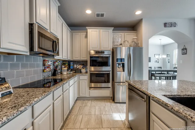 a kitchen with stainless steel appliances granite countertop a refrigerator and a sink
