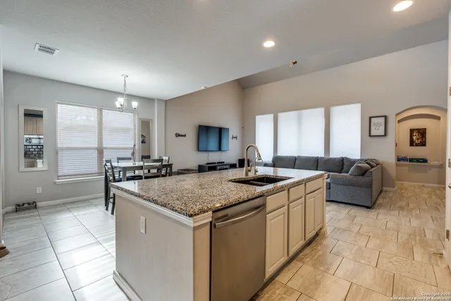 a kitchen with stainless steel appliances granite countertop a sink and a refrigerator