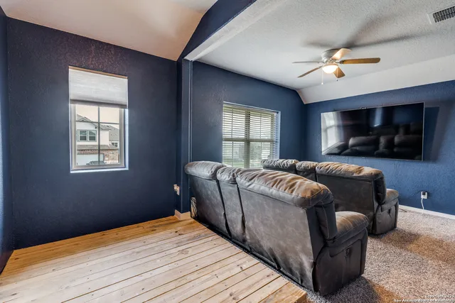 a living room with a bed furniture and a flat screen tv