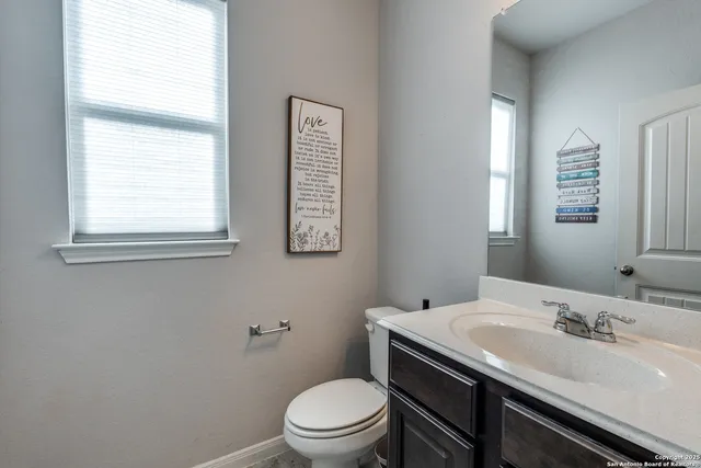 a bathroom with a sink a toilet and a window