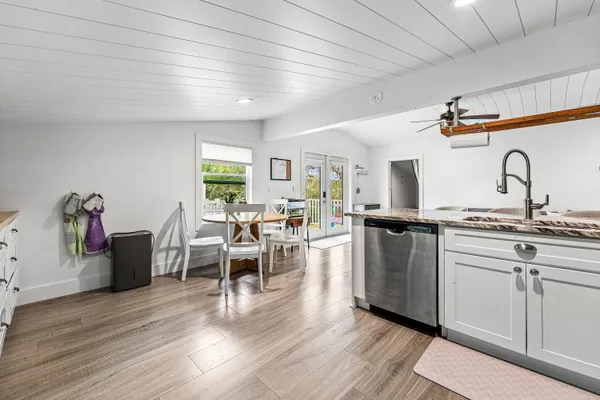 a kitchen with stainless steel appliances kitchen island granite countertop a table chairs and a refrigerator