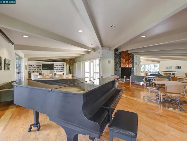 a living room with dining room and couches with wooden floor