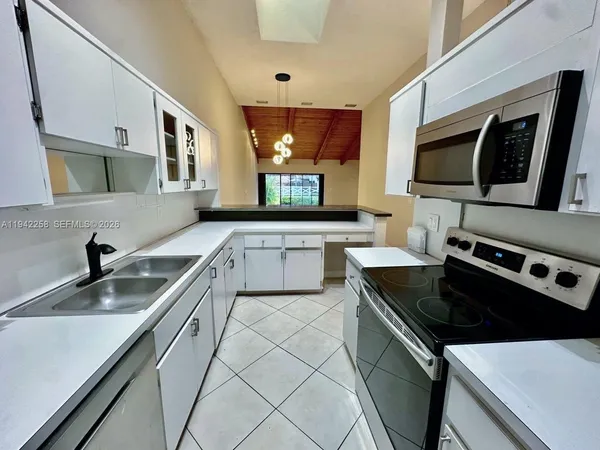 a kitchen with a sink stove top oven and microwave