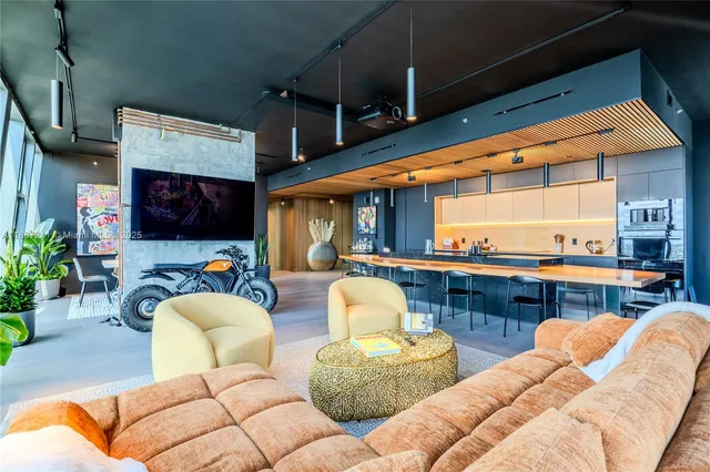 a living room with furniture kitchen view and a large window