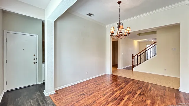 a view of a room with wooden floor staircase and a chandelier