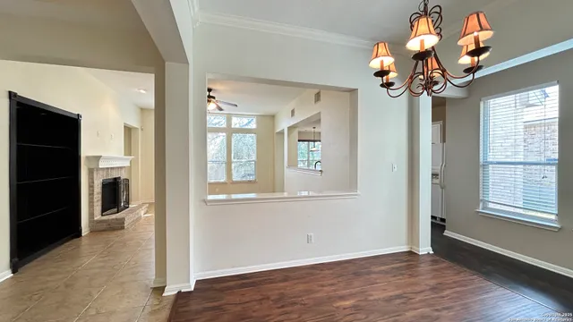 a view of a hallway with wooden floor and a chandelier