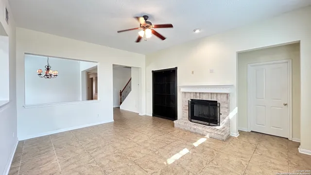 a view of a livingroom with a ceiling fan a fireplace and a ceiling fan
