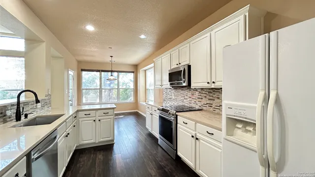 a kitchen with stainless steel appliances a stove sink and microwave