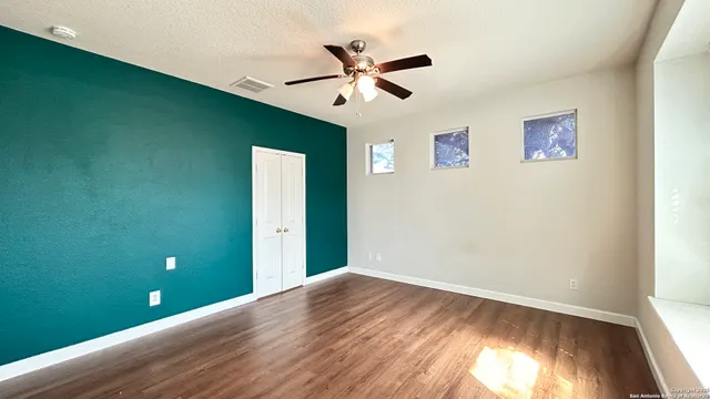 a view of empty room with wooden floor