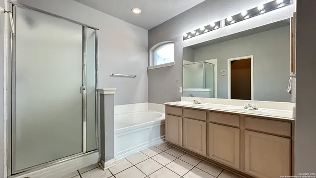a bathroom with a tub a sink and mirror