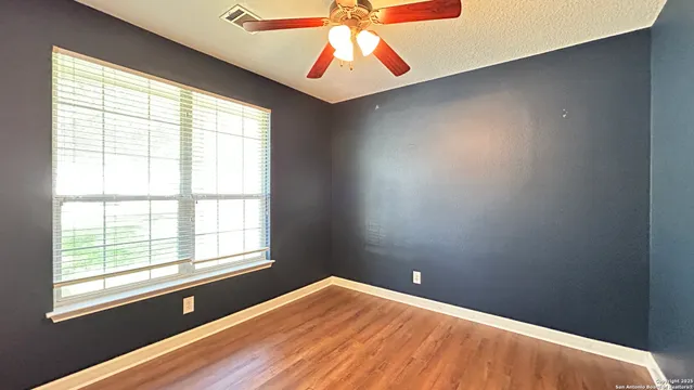 wooden floor in an empty room with a window