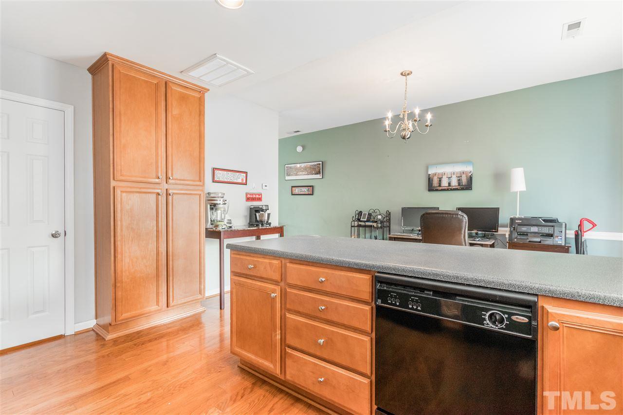 2131 Piney Brook Road, Unit 103 Raleigh, NC 27614 - Photo 8 of 18 a kitchen with granite countertop cabinets a sink a stove a dining table and chairs