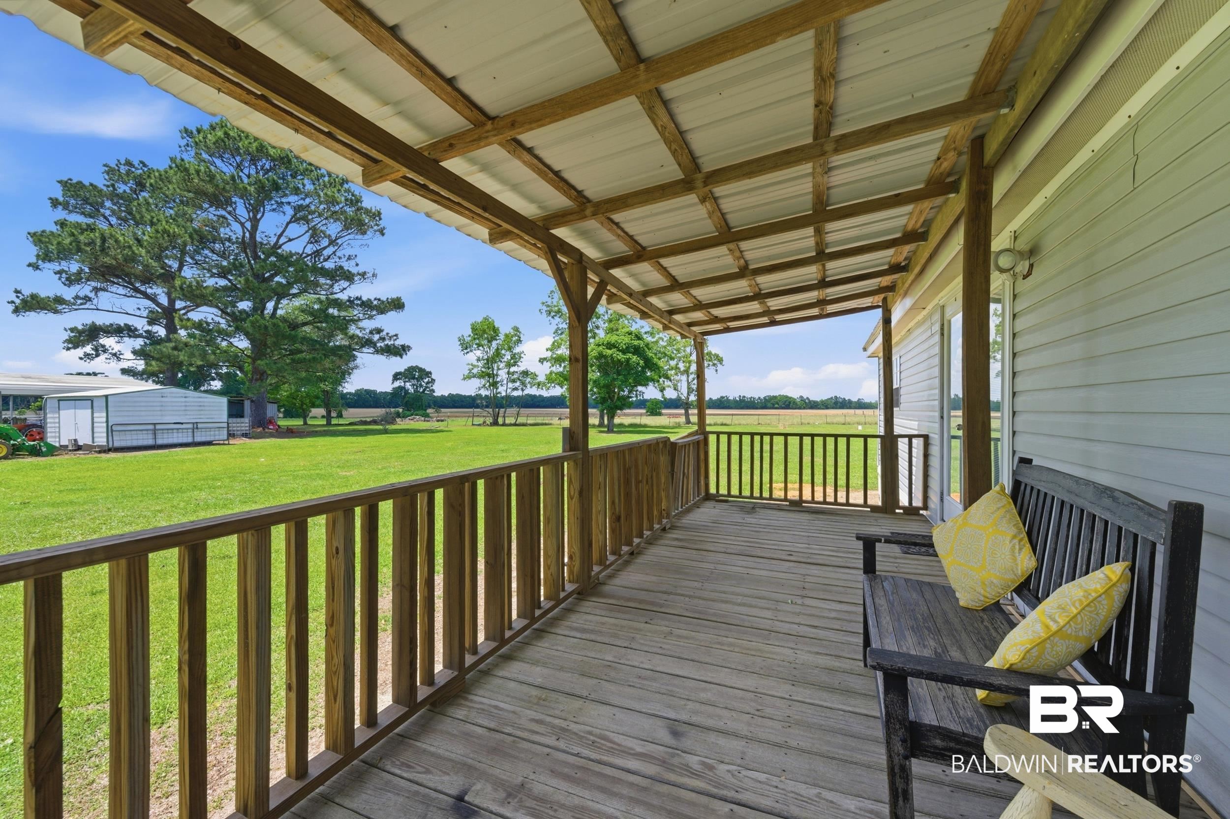 926 Tumbling Lane Atmore, AL 36502 - Photo 10 of 56 Covered wooden porch with a metal roof