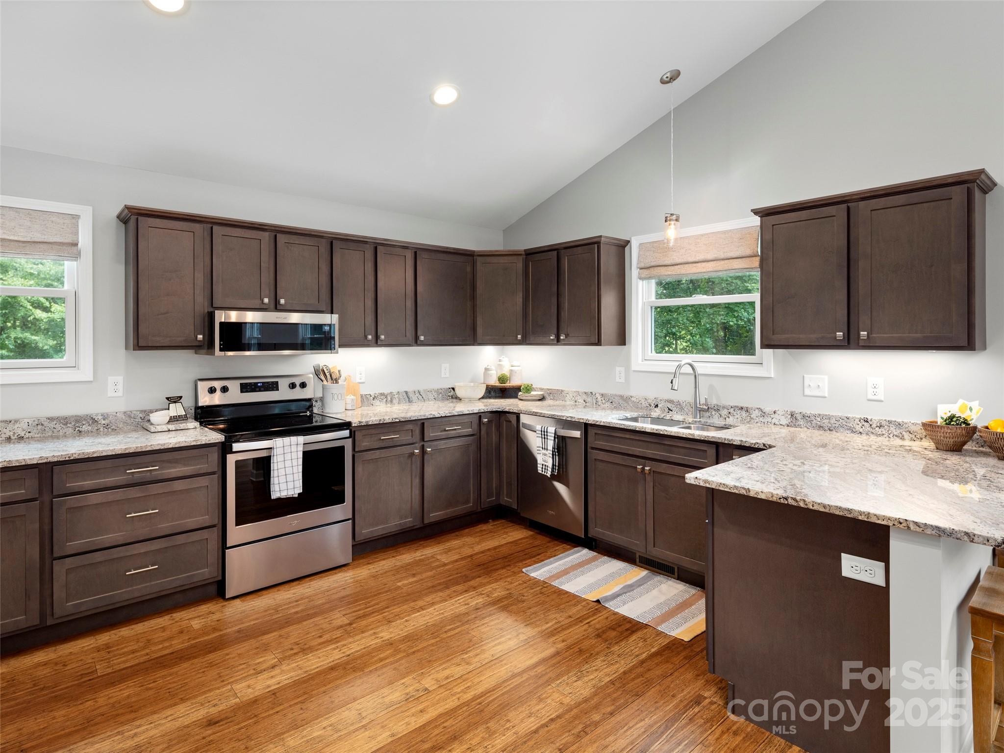 269 Adams Drive Clyde, NC 28721 - Photo 13 of 32 a kitchen with granite countertop a sink cabinets and stainless steel appliances