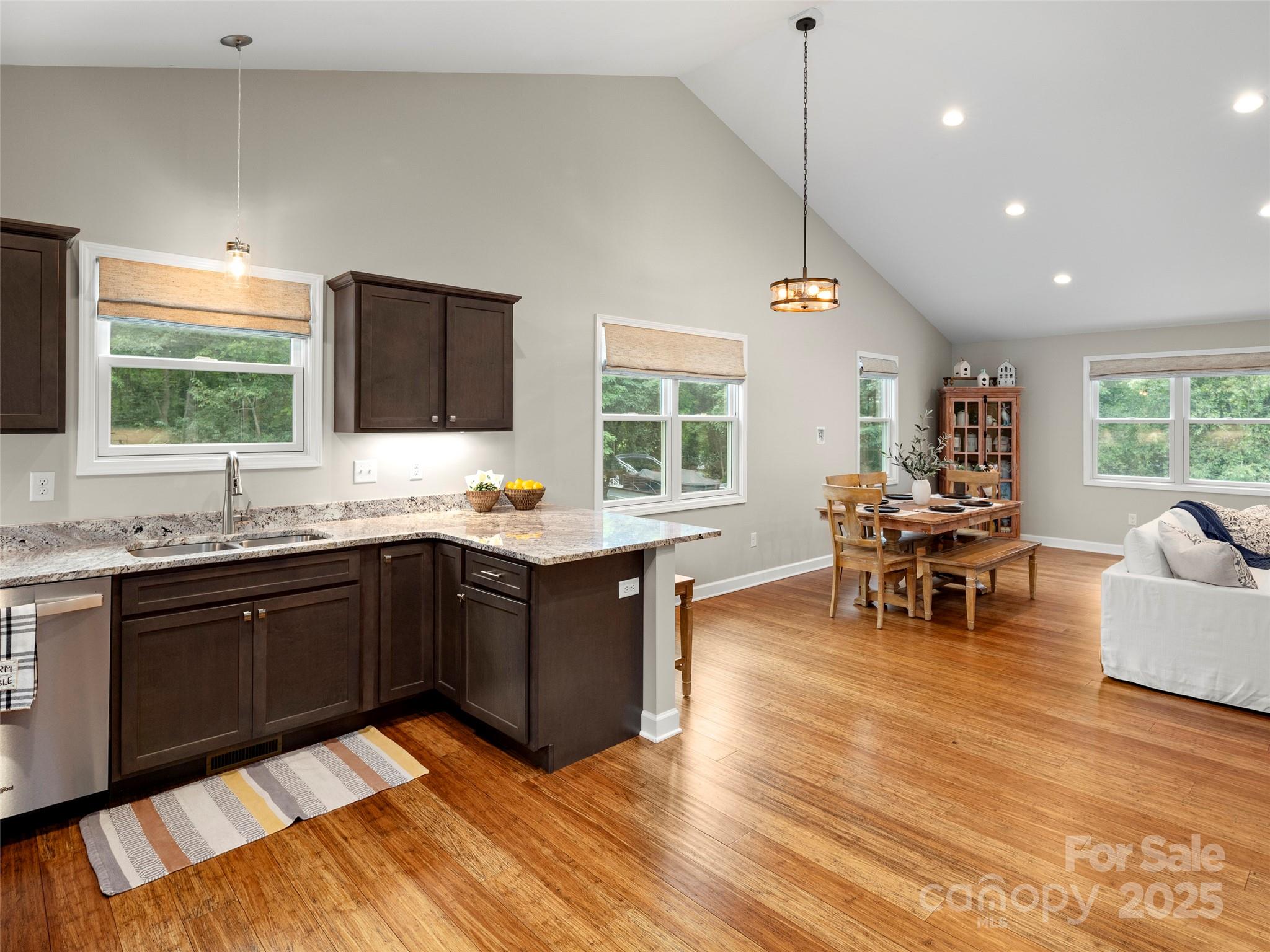 269 Adams Drive Clyde, NC 28721 - Photo 14 of 32 a kitchen with stainless steel appliances granite countertop a stove top oven a sink dishwasher and white cabinets with wooden floor