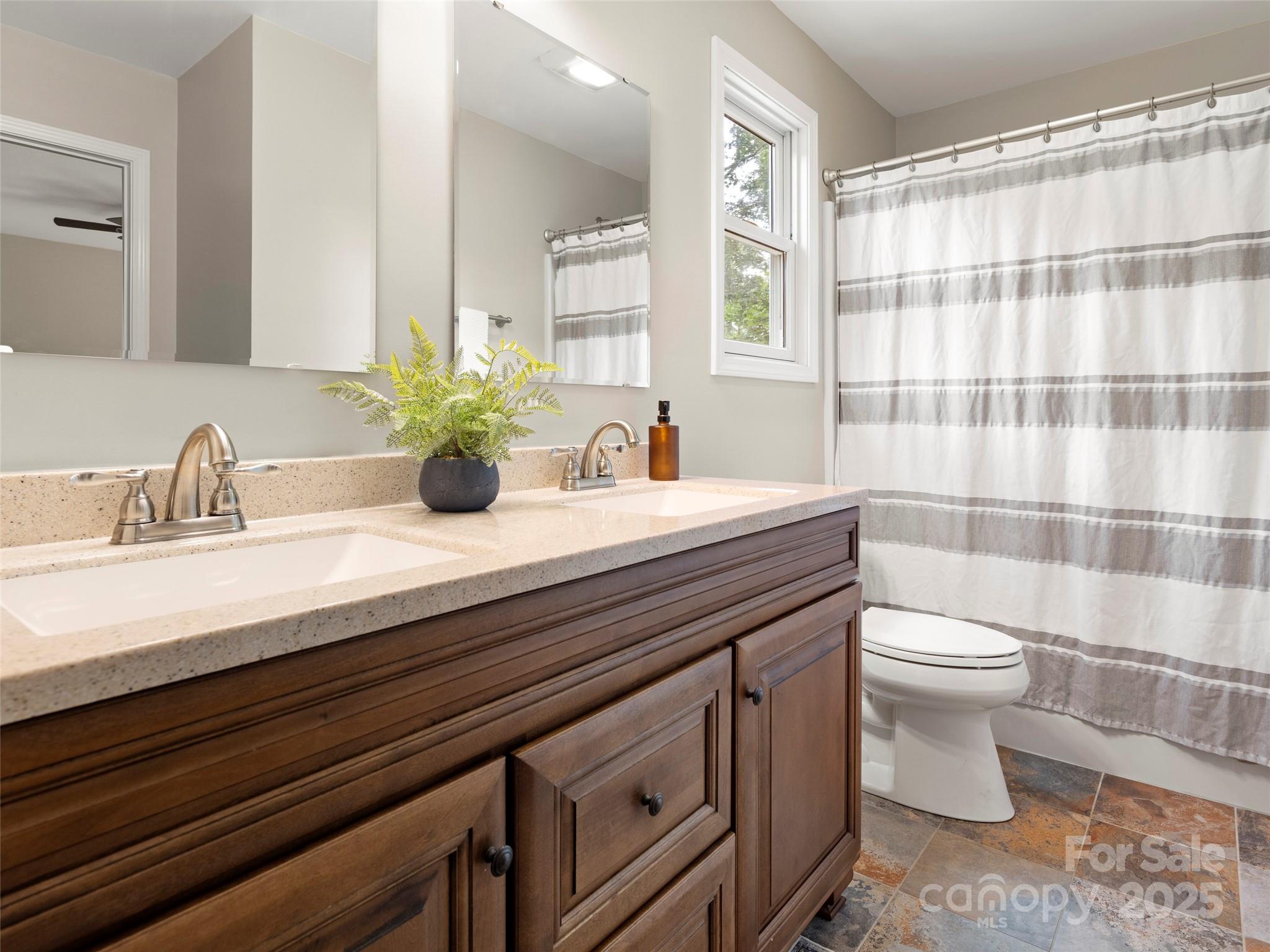 269 Adams Drive Clyde, NC 28721 - Photo 24 of 32 a bathroom with a sink a toilet and shower curtain