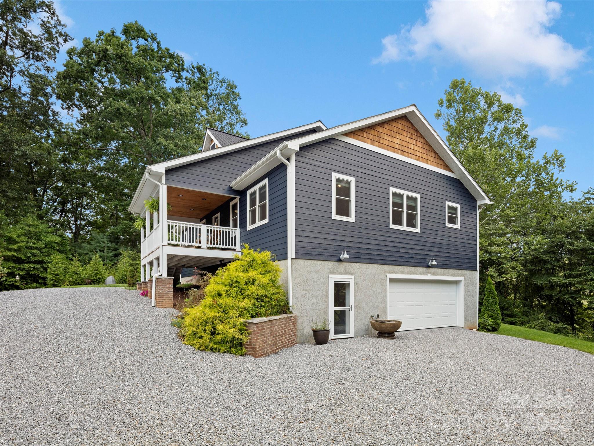 269 Adams Drive Clyde, NC 28721 - Photo 30 of 32 a front view of a house with a garden and garage