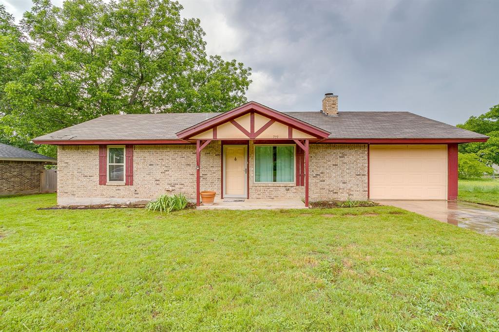 709 North Ave B Springtown, TX 76082 - Photo 1 of 32 a front view of a house with a garden