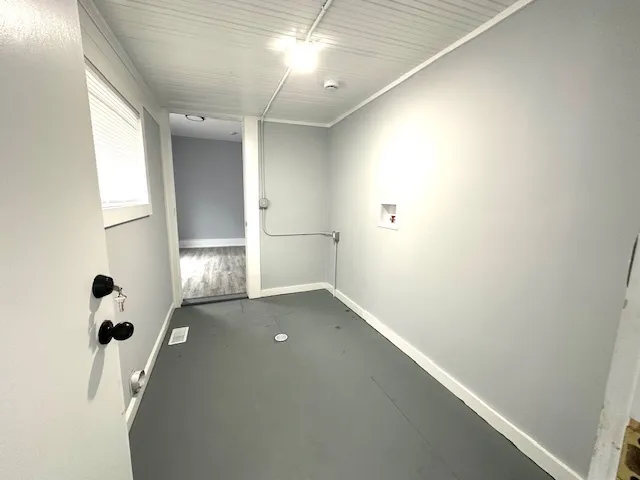 an empty room with wooden floor and mirror