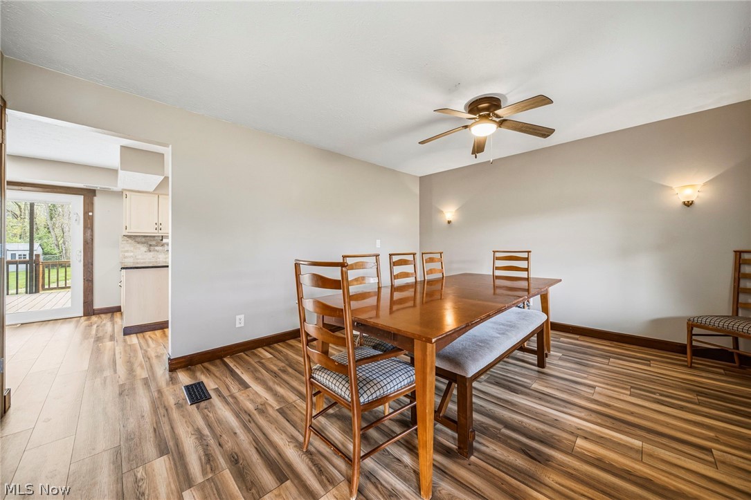 10610 Ridgewater Drive Painesville, OH 44077 - Photo 8 of 23 Spacious dining area featuring wood-finish flooring, a ceiling fan with integrated lighting, and two wall sconces