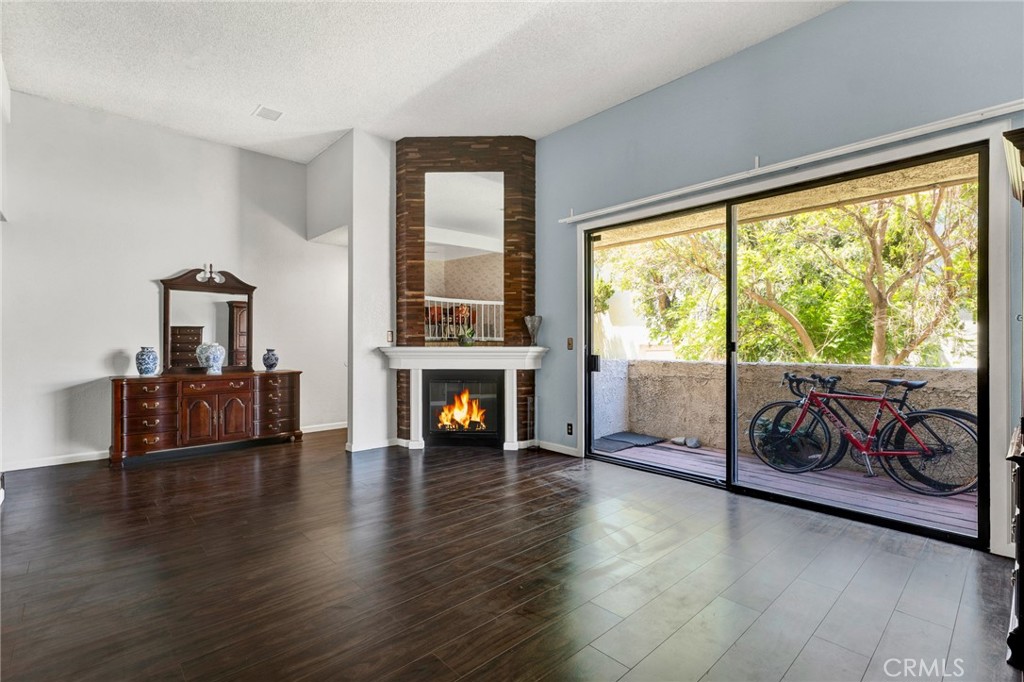 a living room with fireplace furniture and a floor to ceiling window