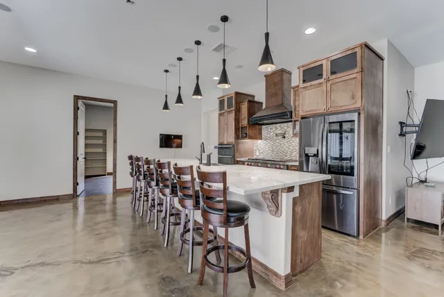 a kitchen with stainless steel appliances kitchen island granite countertop a table and chairs