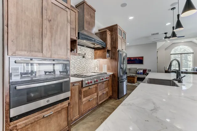 a kitchen with stainless steel appliances granite countertop a stove and a sink