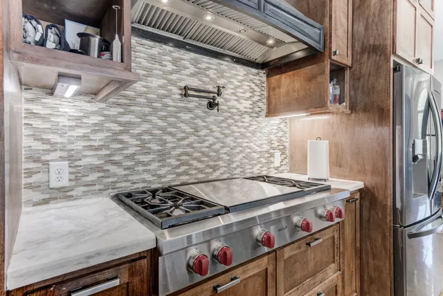 a stove top oven sitting inside of a kitchen