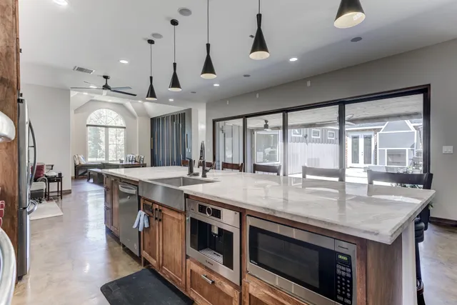 a large kitchen with kitchen island a stove a sink a dining table and chairs