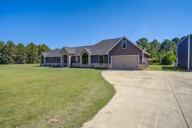 a front view of a house with a garden and yard