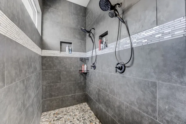 a bathroom with a bathtub shower sink vanity mirror and toilet