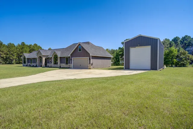 a front view of a house with a garden and yard